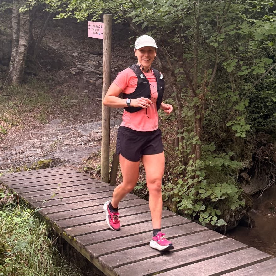 Run the Pyrenees runners crossing a wooden riverside boardwalk in Ordino