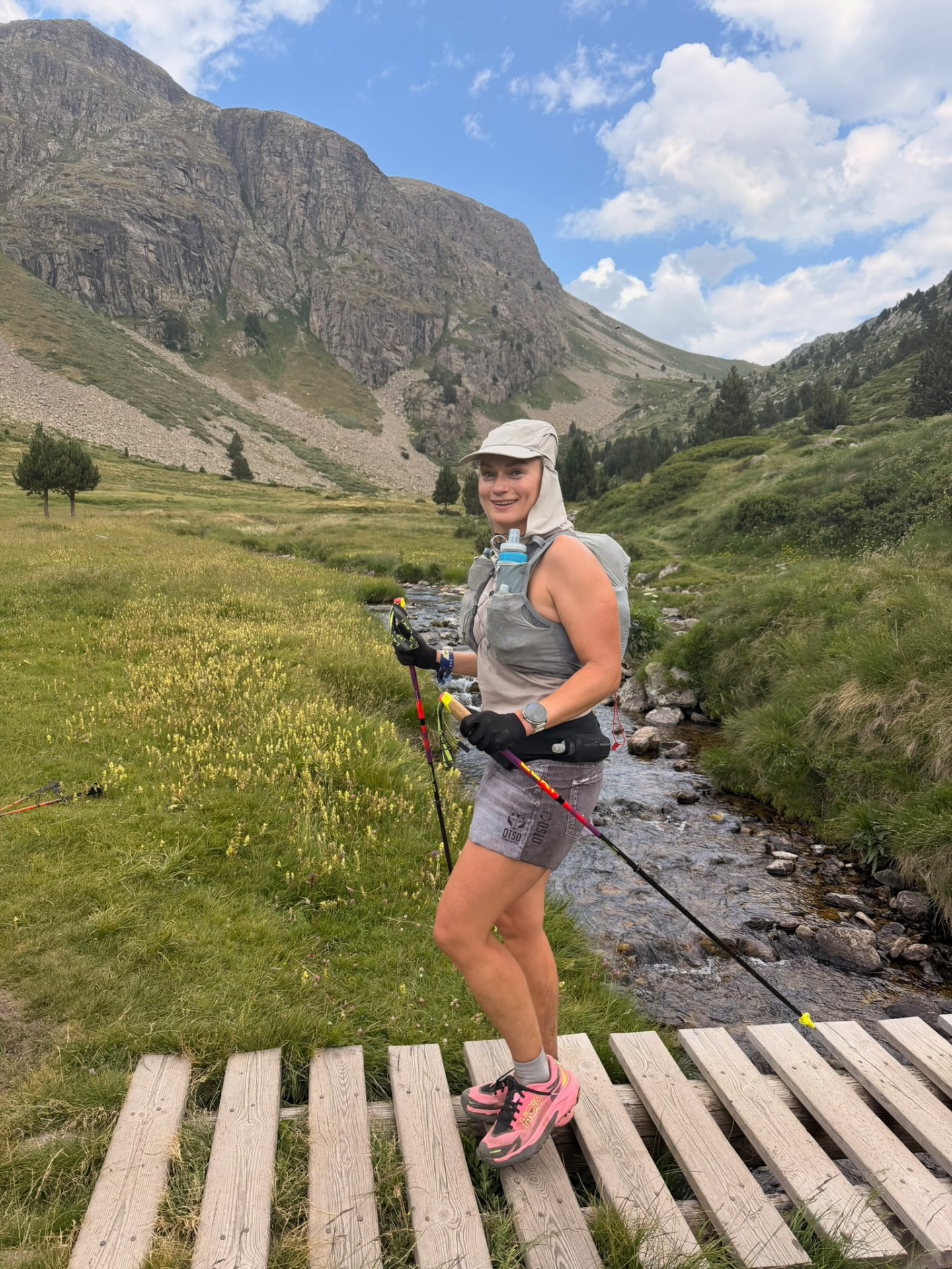 Run the Pyrenees runner smiling on a wooden bridge over a mountain stream