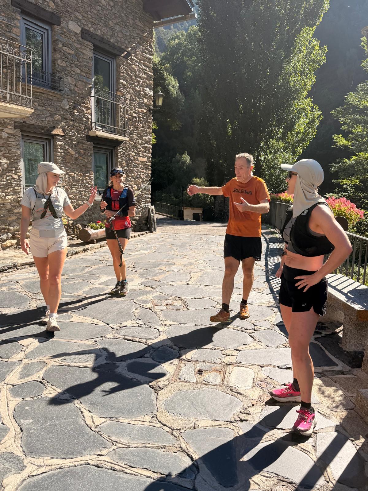 Run the Pyrenees runners chatting on a stone village street in Ordino before a run