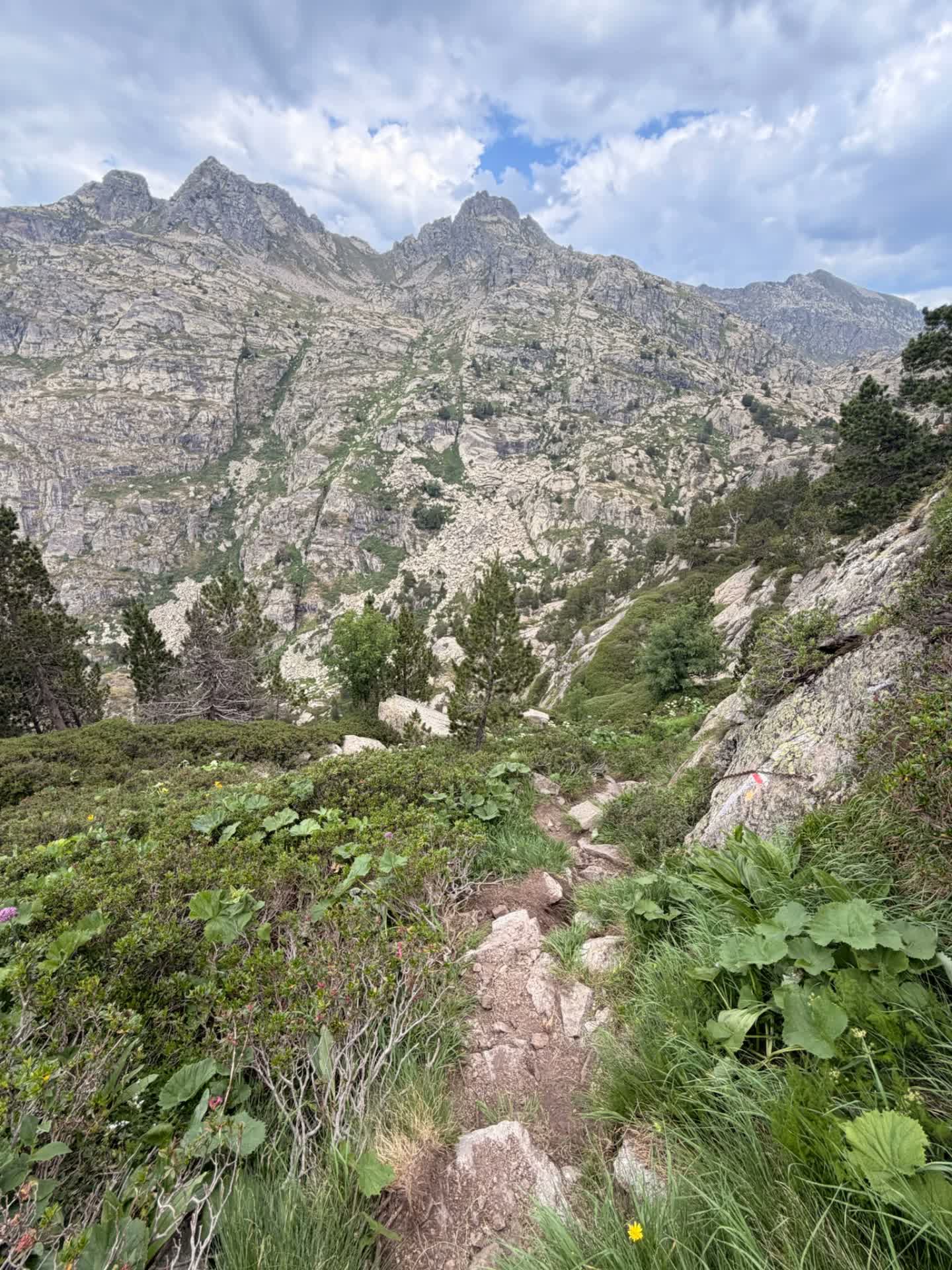 Rocky singletrack climbing toward granite peaks in the Andorran Pyrenees